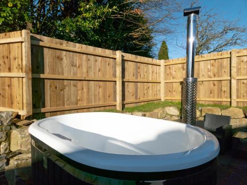 a bath tub in a yard next to a fence at Suite 14 - Sleeping Giant Hotel - Pen Y Cae Inn in Brecon