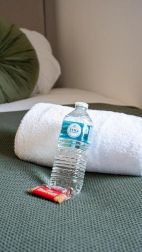 a bottle of water sitting on top of a bed at Mercer Apartment in Alloa