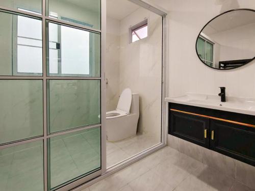 a bathroom with a toilet and a sink and a mirror at Baan Klangkao - บ้านกลางเขา สะปัน in Ban Huai Ti
