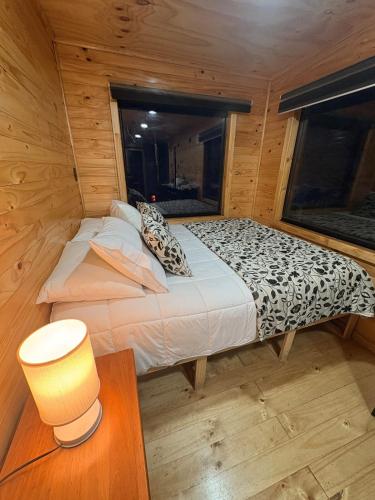 a bedroom with a bed in a wooden cabin at Mini house in Torres del Paine in Cerro Castillo