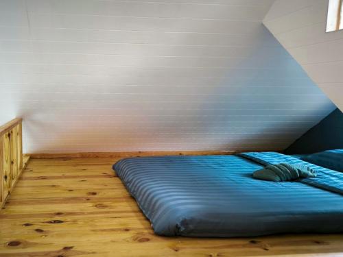 a blue bed in a room with a wall at Baan Klangkao - บ้านกลางเขา สะปัน in Ban Huai Ti