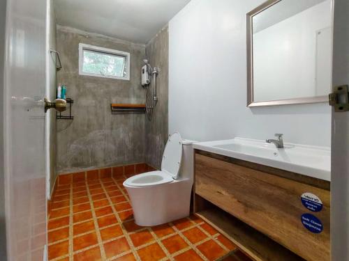 a bathroom with a toilet and a sink at Baan Klangkao - บ้านกลางเขา สะปัน in Ban Huai Ti