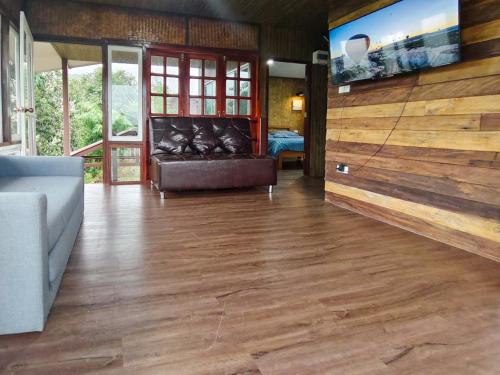 a living room with a couch and a flat screen tv at Baan Klangkao - บ้านกลางเขา สะปัน in Ban Huai Ti