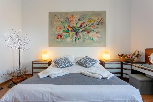 a bedroom with a bed with a painting on the wall at Dimora Aurelia Rome & Sea in La Massimina-Casal Lumbroso