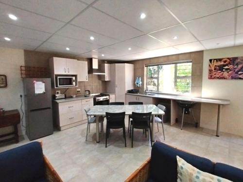 a kitchen with a table and chairs in a room at Ce-la-vie in Gqeberha