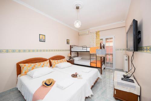 1 Schlafzimmer mit 2 Betten, einem TV und einem Schreibtisch in der Unterkunft Villa Psaropouli in Dragotiná