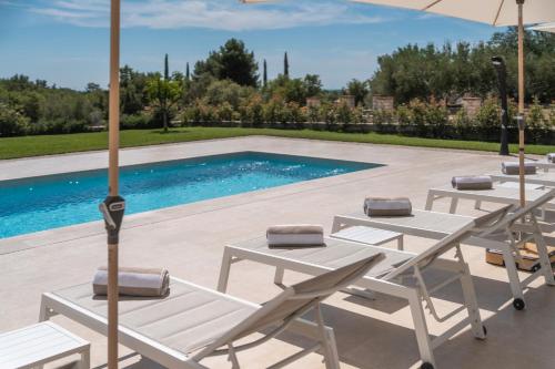 a group of tables and umbrellas next to a pool at Villa Juki by Briskva in Kaštel