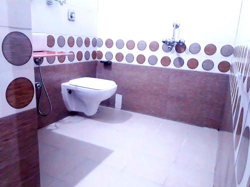 a bathroom with a white toilet in a room at Samant Beach Resort in Malvan