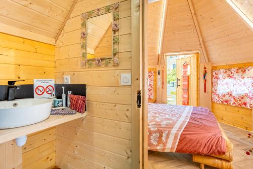 a bathroom in a wooden cabin with a sink at Les Philous Gourmands in Sevremont