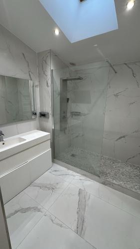 サン・モール・デ・フォッセにあるCosy F2 à Saint Maur des Fossésのシャワーと洗面台を備えた白いバスルーム