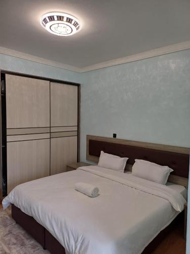 内罗毕Blonch's Airbnbs的卧室配有一张白色大床,天花板上设有时钟