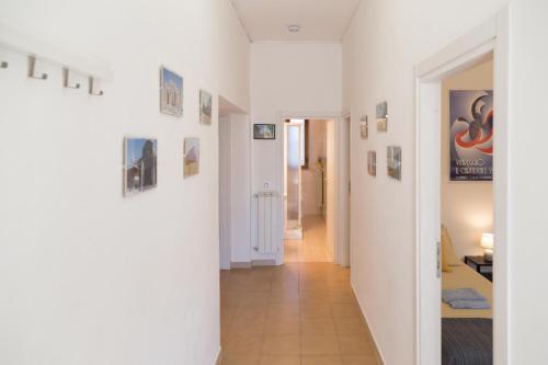a hallway with white walls and pictures on the walls at Casa La Palma in Vecchiano