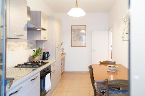 a kitchen with a table and a stove top oven at Casa La Palma in Vecchiano