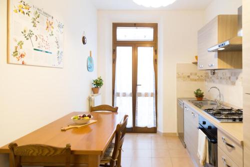 a kitchen with a table with a bowl of fruit on it at Casa La Palma in Vecchiano