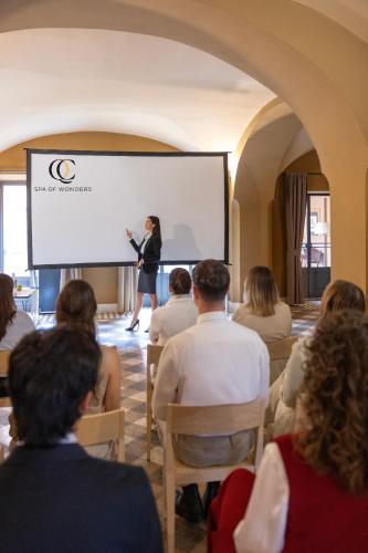 a woman standing on a screen in front of a crowd at QC Grand Hotel Roma in Fiumicino