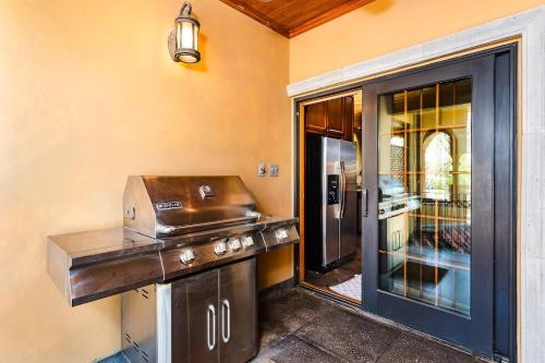 a kitchen with a grill and a glass door at Sunset View Roof Terrace, Steps To The Beach! in Tamarindo