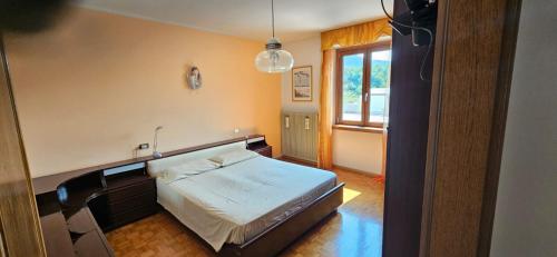a bedroom with a bed and a window at Residenza Ariete Vista Paganella in Terlago
