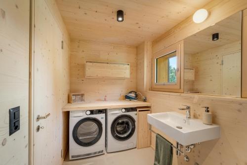 une salle de bain avec une machine à laver et un lavabo dans l'établissement Ruheoase mit Bergsicht, à Churwalden
