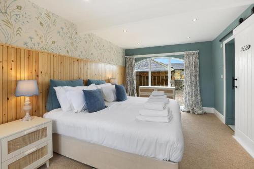 ein Schlafzimmer mit einem großen weißen Bett und einem Fenster in der Unterkunft Mill Cottage - North East Escapes in Belford