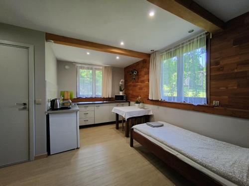 a bedroom with a bed and a small kitchen at ekoLOKUM - kameralnie, blisko centrum in Ostróda