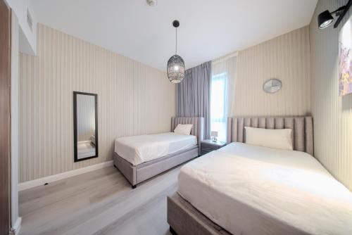 a bedroom with two beds and a mirror at 2BR Private Apartment in Al Zahia, Sharjah - Stone Haven in Sharjah