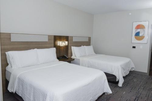 two beds in a hotel room with white sheets at Holiday Inn Express Hotel & Suites Easton by IHG in Easton