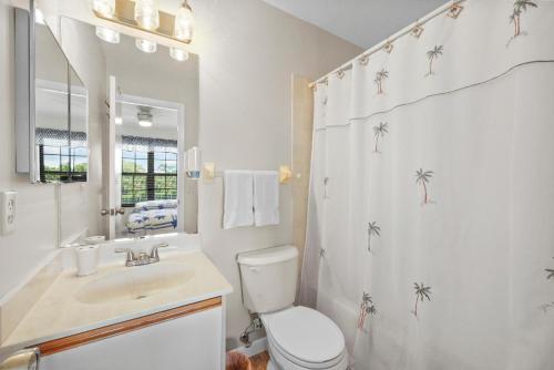 a bathroom with a toilet and a sink and a shower at Cozy townhouse centrally located on the island in Marco Island