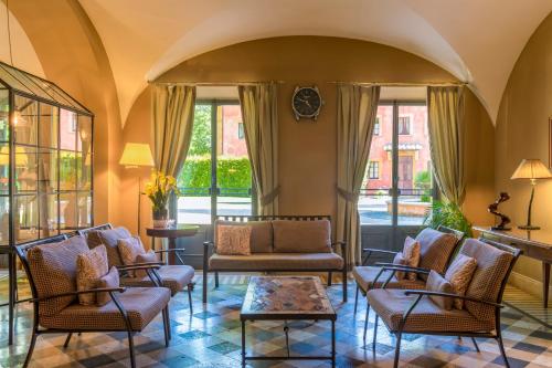 a lobby with chairs and a table and windows at QC Grand Hotel Roma in Fiumicino