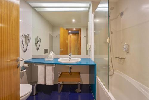 a bathroom with a sink and a toilet and a shower at Hotel Do Caracol in Angra do Heroísmo