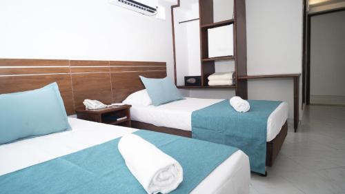 a hotel room with two beds with blue and white at Hotel Portobelo Convention Center in San Andrés