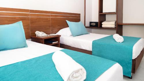 a hotel room with two beds with blue and white at Hotel Portobelo Convention Center in San Andrés