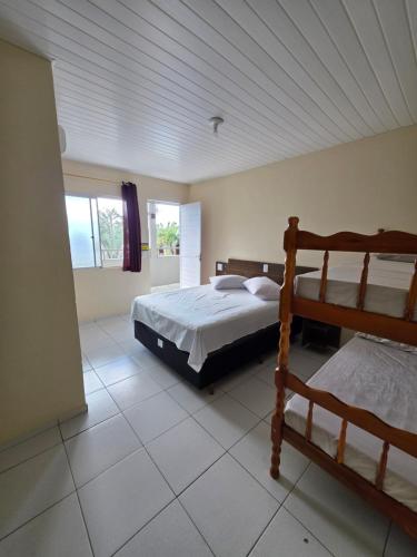 a bedroom with two bunk beds and a tiled floor at Pousada Buenos Aires in Pontal do Paraná