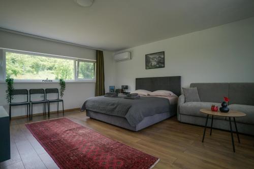 a bedroom with a bed and a couch at OZ - Obecana Zemlja Permaculture Homestead in Blagaj