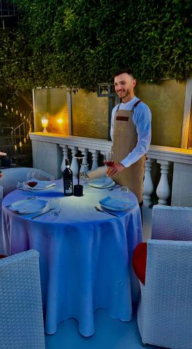 a man standing next to a table in a restaurant at Prince Privé Suite in Goranxi