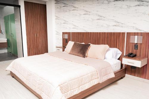 a bedroom with a large bed and a marble wall at Hotel Santiago de Compostella Suites in Cuenca