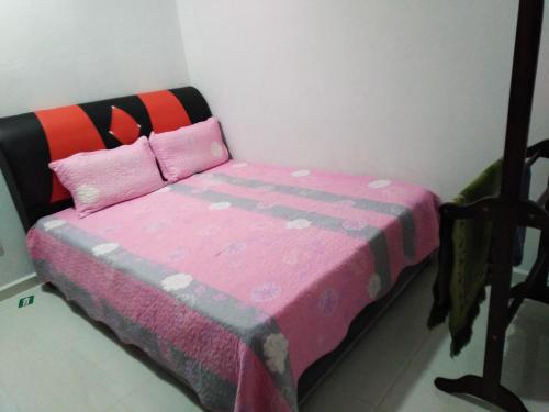 a bedroom with a bed with a pink blanket at Liza Homestay in Bachok