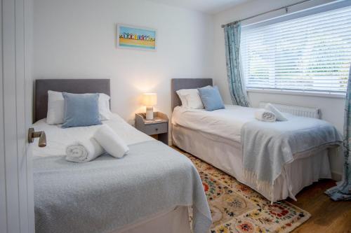 una camera da letto con due letti e una finestra di The Willows - 2 Bedroom Cottage - Oxwich a Oxwich