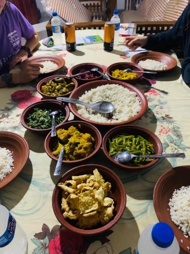 a table with many bowls of food on it at Sigiri Village Vibe Hostel in Sigiriya