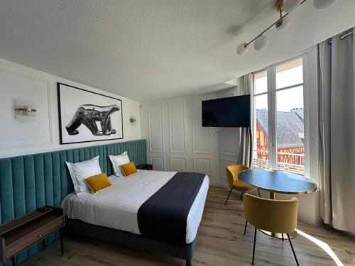 a hotel room with a bed and a table and a window at City Loft Apparthotel in Dijon
