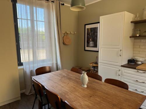 a kitchen with a wooden table with chairs and a window at Maison Eudoise, piscine et spa in Eu