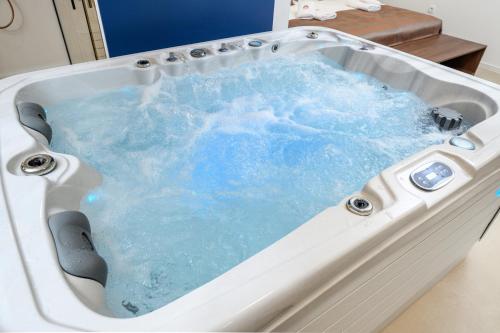 a jacuzzi tub with blue water in it at Rooms & Apartments Podsreda Castle in Podsreda