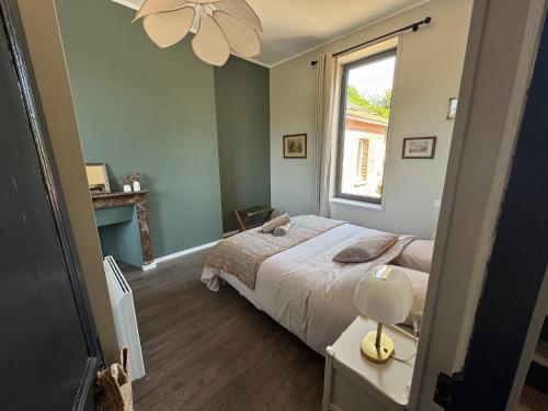 a bedroom with a large bed and a window at Maison Eudoise, piscine et spa in Eu
