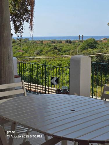 a picnic table on a balcony with a view of the ocean at Un'oasi tra i limoni in Naso