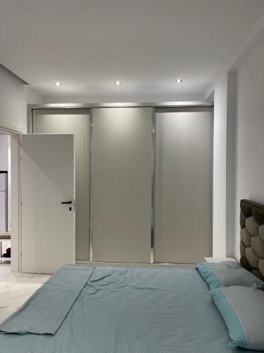 a bedroom with a large bed and sliding doors at Eldi's Home in Vlorë
