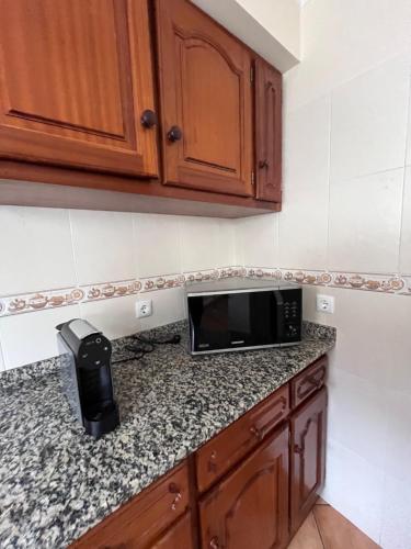a kitchen with a microwave on a counter at Machico Village Apartment in Machico