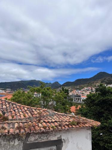 a roof of a building with mountains in the background at Machico Village Apartment in Machico
