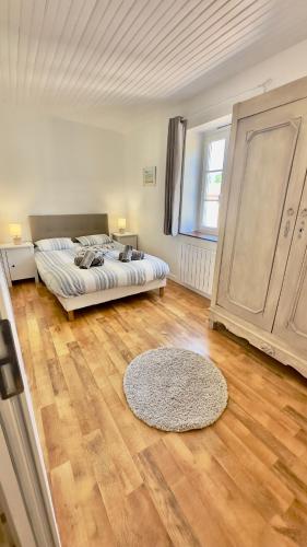 a bedroom with a bed and a rug on a wooden floor at Le Nid près de la Saône in Montmerle Sur Saône