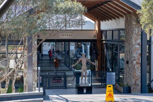 a building with a statue in the middle of a street at #AlimamaSpaces The Phelo's Reid in Sandton