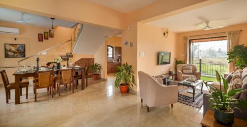 a dining room and living room with a table and chairs at Greenfield · 3BHK Portuguese Villa in Assagao Goa in Goa