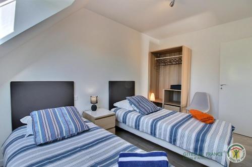 ein Schlafzimmer mit zwei Betten und einem Fenster in der Unterkunft Les agapanthes in Perros-Guirec